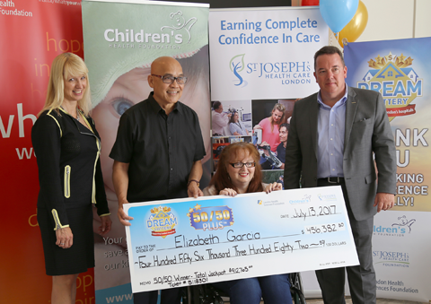 50/50 Plus lottery winner Elizabeth Garcia (seated) and her husband Antonio (second from left) receive their big cheque from LHSF Chief Operating Officer Evelyn Salhani (left) and CHF President & CEO Scott Fortnum (right).