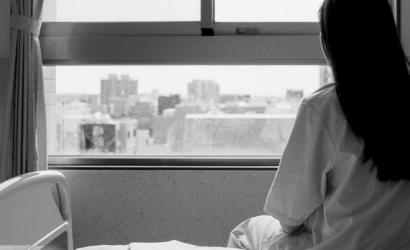 Woman looking out the window of her hospital room.