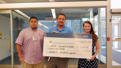 Taylor, James and Jeff smile while holding their big check
