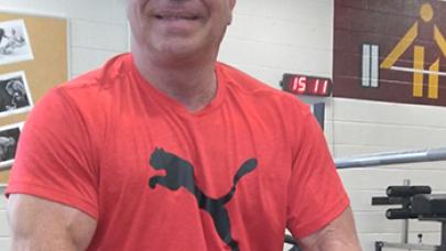 Middle-aged muscle man in red shirt giving a big smile.