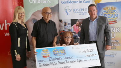 50/50 Plus lottery winner Elizabeth Garcia (seated) and her husband Antonio (second from left) receive their big cheque from LHSF Chief Operating Officer Evelyn Salhani (left) and CHF President & CEO Scott Fortnum (right).